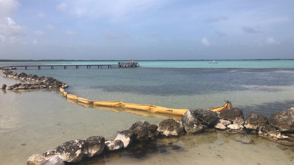 Bij Sorobon Beach Resort probeert men de olie tegen te houden. 