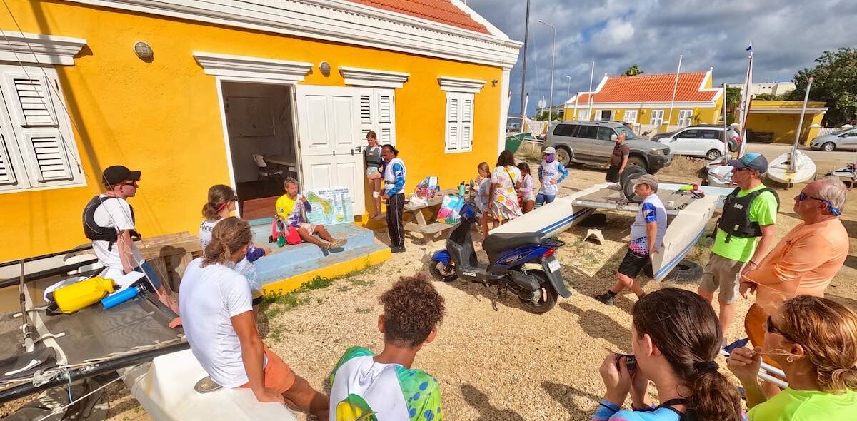 Zeilers luisteren bij Kas de Regatta voor een training.