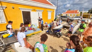 Zeilers luisteren bij Kas de Regatta voor een training.