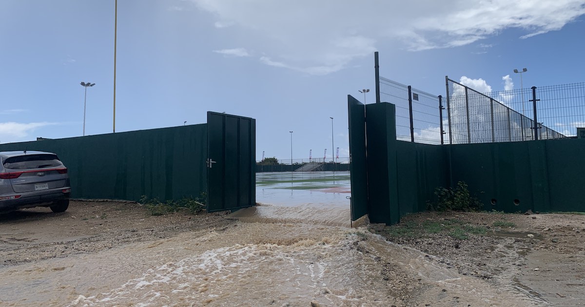 Aan de zijkant van het Jossy Boekhoudt ballpark zijn zijdeuren open gezet om het regenwater eruit te laten.